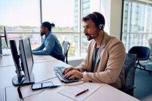 An IT professional at his desk with a headset